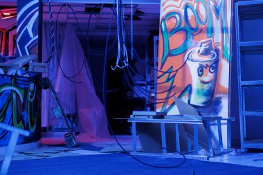 Terk edilmiş bina harabeye döndü ve karanlıkta parlayan floresan neon ışıkları ve paslı gettoyla birlikte. Mor, mavi ve pembeyle parıldayan çürümüş eski boşlukta.