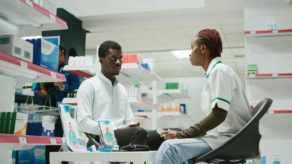 Erkek Müşteri Eczacıya Ilaçları Soruyor Ilaç Takviye Paketlerine Bakıyor Müşteri — Stok fotoğraf