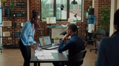 Raporları tartışan iş arkadaşları, yıllık veri sonuçları ve istatistikleri kullanarak kalkınma için yeni bir iş vizyonu yaratmayı planlıyorlar. İşbirliği için analitiği inceleyen insanlar.