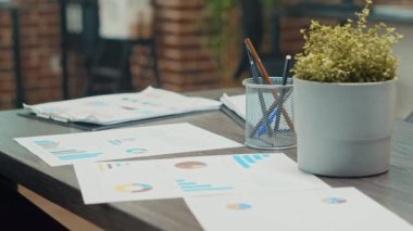 Yıllık veri raporları, iş geliştirme planı ve boş çalışma alanı için kullanılan belgeler. Toplantı masası kağıtlar, kurumsal istatistikler ve işbirliği ile dolu. Kapat..