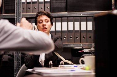 Kadın polis memuru ev telefonunda uzaktan müfettişle konuşuyor, kriminal soruşturma raporlarını tartışıyor. Gece geç saatlere kadar arhiv odasında çalışan özel dedektifler kanıt dosyalarını inceliyor.