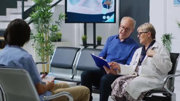 Медик Сидить Стільці Лікарні Пояснюючи Діагноз Хвороби Пацієнтів Похилого Віку — стокове відео