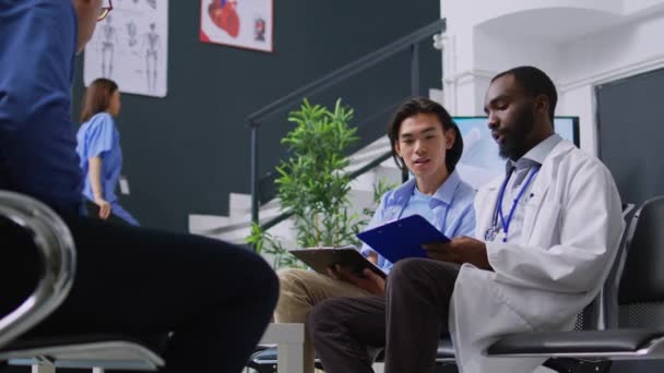 Praktiker Erklärt Dem Asiatischen Patienten Während Des Kontrollbesuchs Die Medizinische — Stockvideo