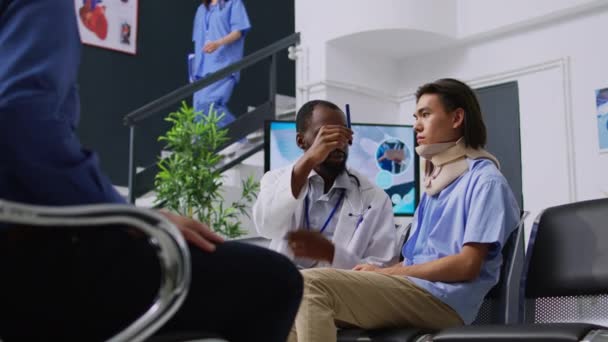 病院の待合室で脳震盪を確認し 診察中に医療処置について話し合う医師 頸椎首の襟をつけて脳損傷検査をしてるアジア人 医学の概念 — ストック動画