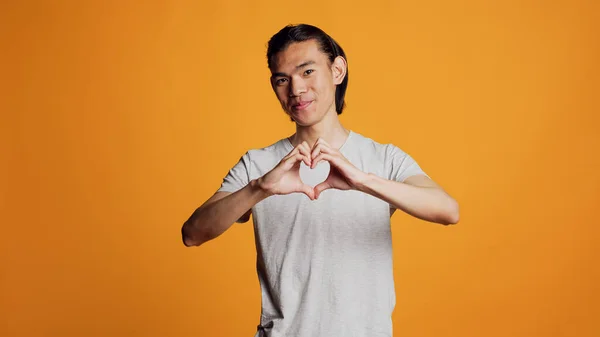 Kendine Güveni Olan Sevimli Bir Adam Kamerada Kalp Şekli Işareti — Stok fotoğraf