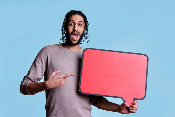 Podekscytowany Arabski Człowiek Trzymając Bańki Mowy Reklamować Produkt Czerwonym Banerze — Zdjęcie stockowe