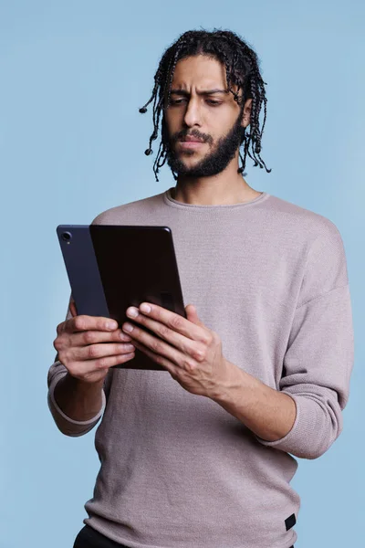 混淆不清的Arab男子滚动软件应用在数字平板电脑和冲浪互联网上 集中人员浏览应用程序 并在手提式小工具上浏览网上新闻 — 图库照片