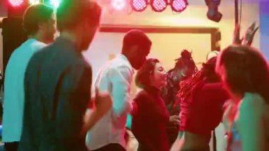 Gençler kulüpte müzik dinlemekten hoşlanıyor, sahnede DJ miksleme istasyonundan elektronik müzik eşliğinde dans ediyorlar. Acayip modern arkadaşlar gece kulübüne gider, müzik sesleriyle eğlenir, parlak spot ışıklarıyla eğlenirler. Üçayak atışı.