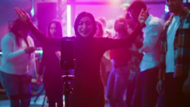 女性为社交媒体拍摄博客 在舞池的夜总会使用智能手机 年轻人录下朋友们一起跳舞和聚会 娱乐的有趣视频 手持射击 — 图库视频影像