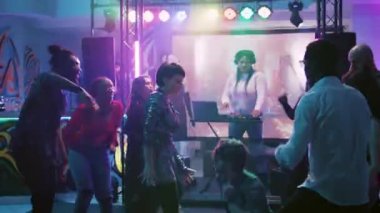 Erkekler ve kadınlar disko partisinde doğaçlama dans savaşı yaparlar, dans pistinde elektronik müzik ve sahne ışıklarıyla dolaşırlar. Genç dansçılar eğlenceli hareketler sergiliyor. El kamerasıyla..