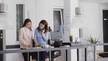Masada yatırım planı üzerinde çalışan çeşitli insanlar, ofiste kalkınma için yeni bir strateji oluşturuyorlar. İş kadını iş yerinde iş arkadaşlarıyla cep telefonuyla konuşuyor..