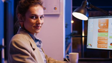 Kafkasyalı iş kadını, veri diyagramlarıyla araştırma planlamak için bilgisayarı kullanarak masa başında proje başlatmayı planlıyor. Kadın danışman gece geç saatlerde analitik ve istatistikleri kontrol ediyor. El kamerasıyla..