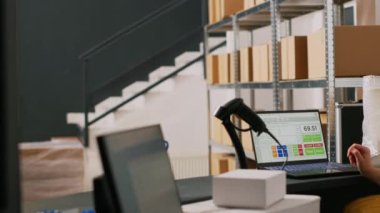 Erkek işçi perakende teslimatı için kutular dolusu mal hazırlıyor. Lojistik siparişleri listesini kontrol ediyor. Depoda içi mal dolu paketler taşıyan genç yetişkinler, kalite kontrol..