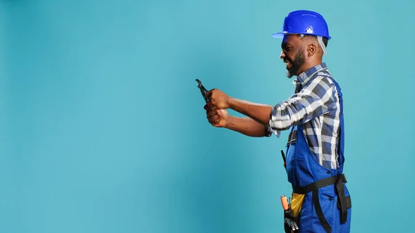 建設労働者は 建物や改修作業のための大工道具を使用して スタジオでレンチで何かをクランプします スパナ工作機械で働く男性コンストラクタ — ストック写真