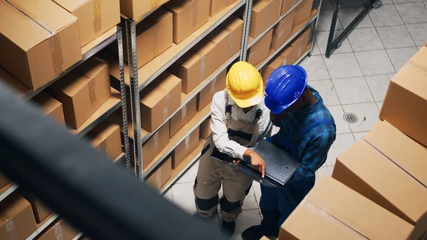 非裔美国人在仓库里使用笔记本电脑和平板电脑 用纸板箱包装商品 仓库员工检查货架和货架 运送货物 — 图库照片