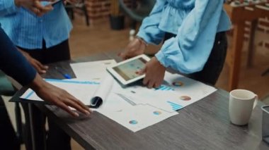 Kağıtların istatistiklerini inceleyen işçiler, kalkınma için iş projesi planı üzerinde birlikte çalışıyorlar. Dosyaları ve dijital tableti kullanarak, yeni yönetici veri raporunu kolaçan eden bir grup çalışan.