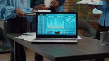 Laptop toplantı odasında online analitik verileri çalıştırıyor, iş adamları yeni geliştirme stratejisini tartışıyor. Resmi kurumsal bilgiler ve istatistiklerle yıllık raporlar.