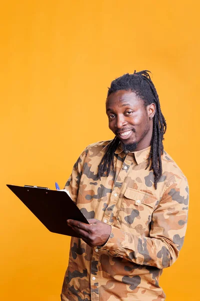 Leende Man Antecknar Anteckningar Bärbara Filer Med Penna Studio Afrikansk — Stockfoto