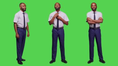 Girişimci, yeşil ekran arka planında kameraya poz veriyor. Stüdyoda kendine güvenen ve şık bir şekilde takım elbise giyiyor. Profesyonel işadamı iyimser hissediyor.