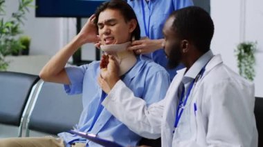 Asyalı bir hastanın boyun kırığından rahim boynu boynundaki tasmayı alan tıbbi personel kazadan sonra fiziksel ağrıya göğüs geriyor. Doktor ve hemşire yaralı adama destek veriyor..