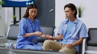 Hemşire glukometre kullanarak kan örneğinde insülin ve glikoz seviyesini ölçüyor. Diyabet hastası Asyalı bir hastaya danışıyor. Muayene sırasında diyabetik adamla tıbbi test yapıyor..