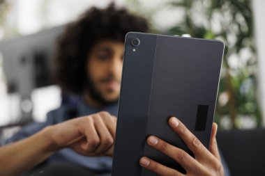 Büroda çalışırken elinde dijital tablet tutan Arap girişimci. Şirket genç pazarlama müdürü internette sohbet ediyor ve internette bilgi arıyor.