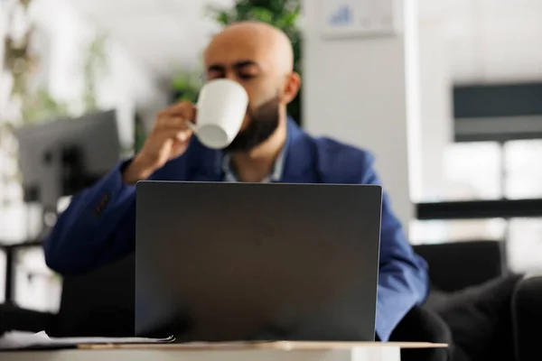 アラブの従業員はコーヒーを飲んで ラップトップ上で製品開発を開始する作業 若い男起業家ビジネスオフィスの職場デスクで企業戦略計画を分析 — ストック写真