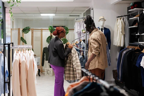 Giyim Mağazası Asistanı Alışveriş Merkezinin Giyim Bölümünde Gömlek Seçen Müşterilere — Stok fotoğraf