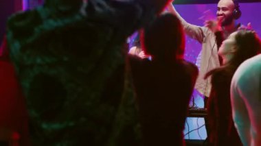 Sahnede karaoke yapan kendine güvenen bir kadın gece kulübünde erkek DJ 'le şarkı söylüyor. Mutlu kız kulüpteki ses karıştırma istasyonunun yanında canlı perfromantizm ile eğleniyor..