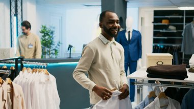Alışverişkolik bir insan giyim mağazasından resmi giysiler alıyor, yeni moda ürünler almak ve gardırobu geliştirmek istiyor. Modaya uygun pazar yerini ziyaret eden erkek müşteri, ticari faaliyet.