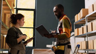 Personel ekibi üretim listesi, ambalaj ve küçük işletmeler için dağıtım malzemelerini inceliyor. Perakende satış sektöründe kargoyla çalışan iki kişi..