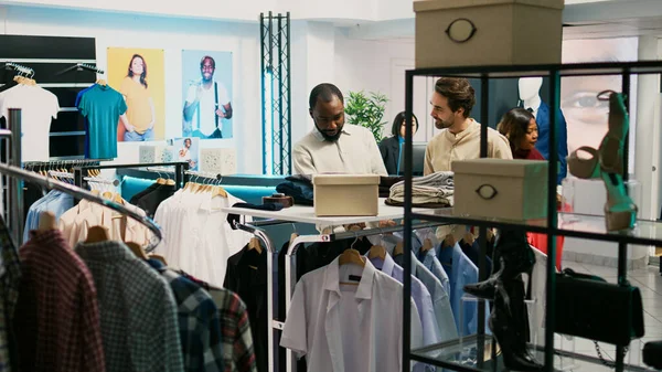 Чоловічий Клієнт Вивчає Нові Товари Магазині Запитуючи Співробітника Про Модну — стокове фото