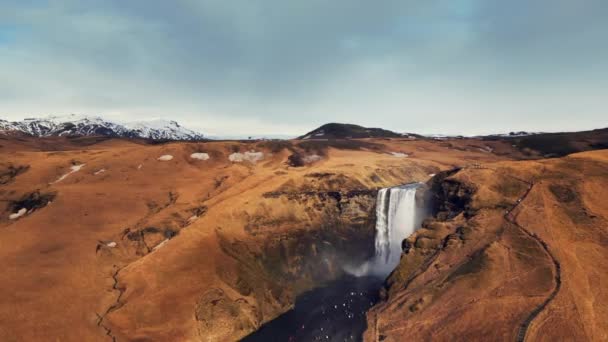 从冰冻的悬崖峭壁上掉下来的北方骷髅瀑布的无人机镜头 创造了美丽的冰岛景观 从五彩斑斓的山丘上喷涌而出的巨大的丑闻 慢动作 — 图库视频影像