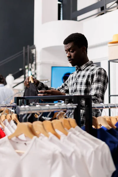 Amerykański Klient Chce Kupić Koszulę Patrząc Kolorowe Ubrania Nowoczesnym Butiku — Zdjęcie stockowe