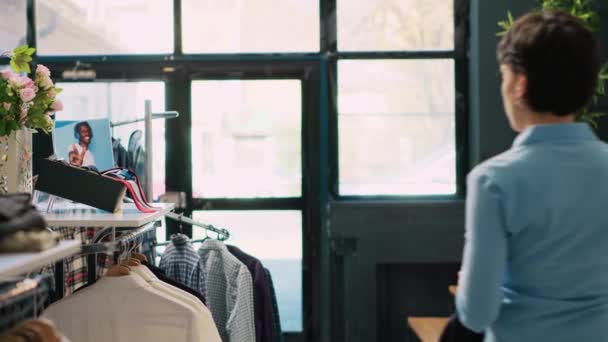 Ukládat Zaměstnance Uspořádání Ramínka Plná Stylového Oblečení Pracuje Moderním Butiku — Stock video
