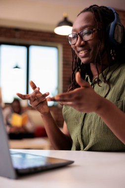 Kablosuz kulaklıklı öğrenci portresi. Erkek arkadaşı dinlenirken arkadaşlarıyla görüntülü konuşma yapıyor. Uzaktan kumandalı çalışan Afrikalı Amerikalı serbest yazar online toplantı yapıyor..