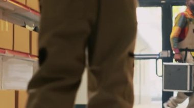 Depodaki envanter listesini doğrulayan, raflardaki ürünleri kontrol eden genç bir yetişkin. Lojistik ve sipariş sevkiyatı için malları düzenleyen depo amiri, teslimat servisi. El kamerasıyla..