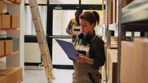 Young Employee Reviewing Cargo List Warehouse Space Examining Shelves Filled — Stock Video