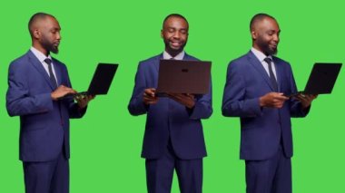 Takım elbise yöneticisi kamerada dizüstü bilgisayarla çalışıyor ve kablosuz bilgisayar ile çevrimiçi ağ sayfasına göz atıyor. Taşınabilir bilgisayarı ve yeşil ekranı olan internet sitesi kullanan genç bir iş adamı.