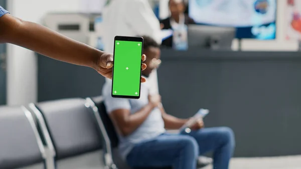 病院の受付でクロマキーディスプレイを使用して 緑の画面で携帯電話を保持する女性の専門看護師 孤立したコピースペースを見ている人モックアップの背景 待合室 — ストック写真