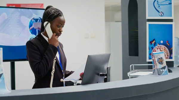 Ung Receptionist Som Arbetar Mottagningsdisken Använder Fast Telefon För Att — Stockfoto