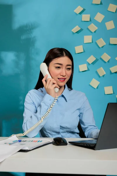 Asyalı Kadını Yönetici Dizüstü Bilgisayarı Kullan Sabit Hattan Müşteriyle Konuş — Stok fotoğraf