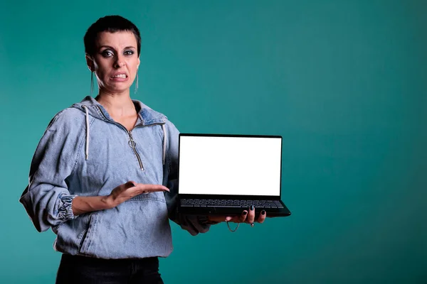 让人失望的是 在独立背景的工作室里 这位不快乐的女士用空白屏幕向笔记本电脑展示了版权空间 悲愤的女人做不喜欢的手势和表情 — 图库照片