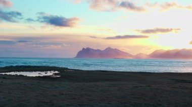 Reykjavik yakınlarında dalgaları olan İzlanda siyah kumsalı, karlı dağları olan doğal kutup manzaraları. Okyanus ve kıyı şeridi ile muhteşem manzaralı rota, Kuzey ülkesi. El kamerasıyla..