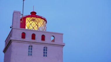 Kıyıdaki Dyrholaey deniz feneri kulesi kıyı şeridinde görkemli ışık feneri. İzlanda sahilinde ışıkları olan eski güzel bir kule yapısı, Atlantik sahil rehberliği. El kamerasıyla..