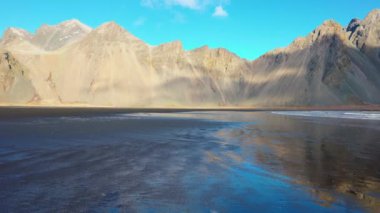 Okyanusla buluşan devasa dağ sıraları, siyah kumlu güzel İzlanda manzaraları. Vestrahorn dağları ve okyanus kıyıları manzaralı Kuzey Kutbu stoksnes yarımadası.