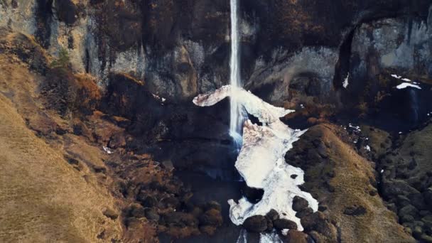 空中俯瞰着在冰原上的小瀑布 从山上滑落 形成了令人眼花缭乱的鸟类景观 北方的风景 美丽的冰雹瀑布从雪山流下 慢动作 — 图库视频影像