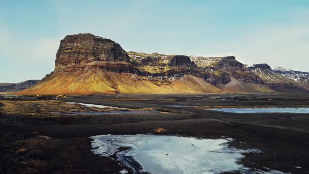 アイスランド 壮大な道端や雪原で雄大な山のドローンショット アイスランドの大規模な丘やスキャンディナヴィアの風景の茶色の凍結土地 スローモーション — ストック動画