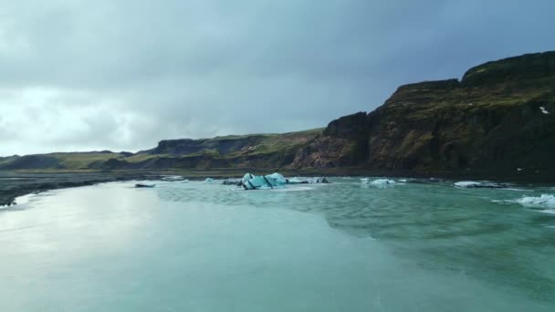 氷のブロックで凍結湖のショットを完了し Vatnajokull氷河のアイスランドの北欧の水の周りに浮かんでいます 氷山や冷凍岩 山や丘と自然氷の風景 スローモーション — ストック動画