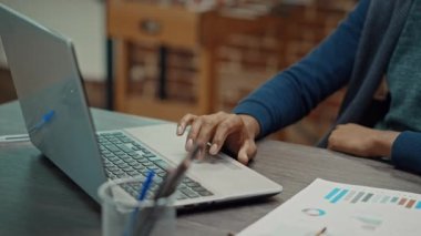 Şirket yöneticisi raporları ve bilgileri okuyarak sunum yapmak için dizüstü bilgisayar kullanıyor. Yıllık veri istatistiklerini inceleyerek iş çözümleri bulmaya çalışan erkek çalışanlar. El kamerasıyla..